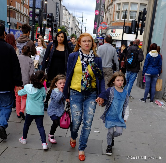 How close you stand depends on the effect you intend to create. However, if you want to shoot someone up close, from a low angle, good luck shooting from across the street.